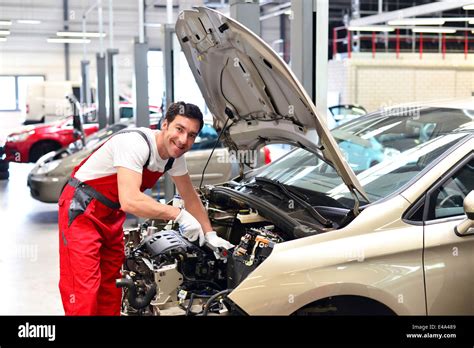 Car mechanic in a workshop working at car Stock Photo - Alamy