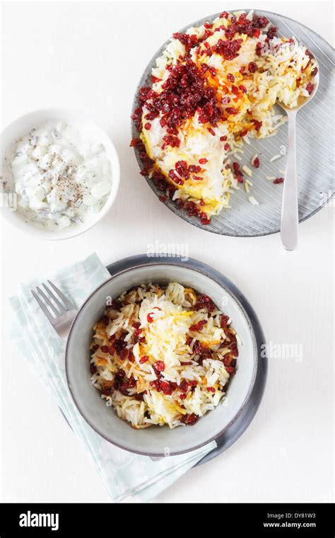 Persian saffron rice with barberries and bowl of mint yoghurt on white background Stock Photo ...