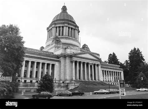 Grainy archival film photograph of the Washington State Capitol Building with cloudy sky. Shot ...