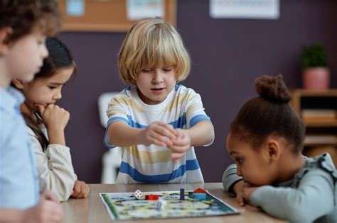 Premium Photo | Diverse group of little kids playing board game together in preschool