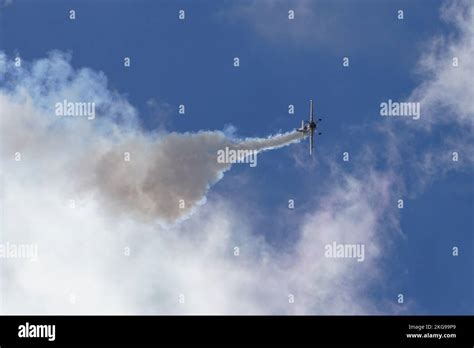 A light sport airplane performing aerobatic maneuver stunts in a cloudy sky, demonstrates its ...