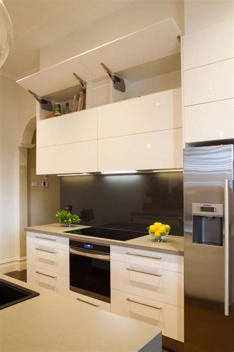 Modern galley style kitchen. Lift up overhead cupboards by Blum. www.thekitchendesigncent ...