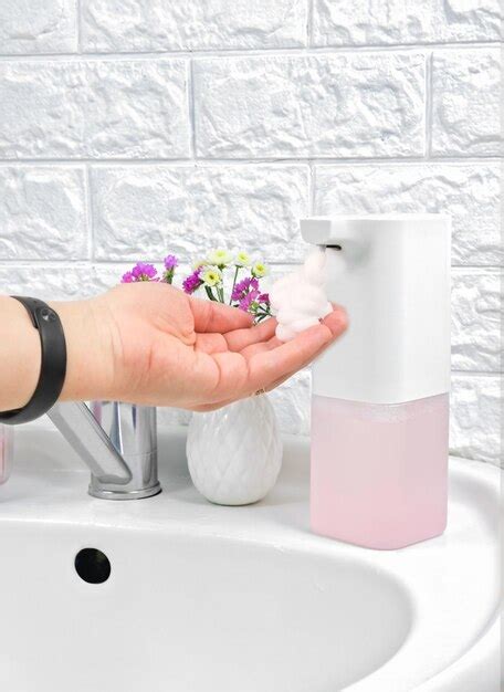 Premium Photo | Female hand using automatic touchless soap dispenser in ...