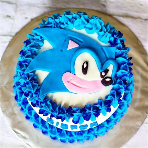 a blue and white birthday cake with an image of a hedgehog on the top