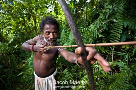 an old man holding a stick and aiming it at something in the air with ...