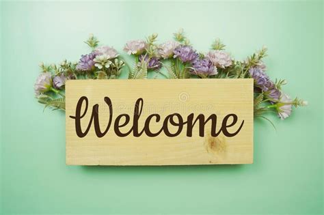 Welcome Sign with flowers frame decorate on green background. Top View ...