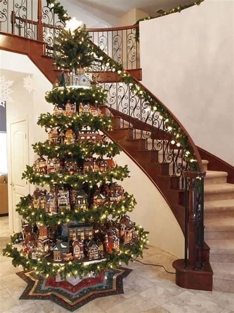 a christmas tree is in the middle of a stair case and decorated with ...