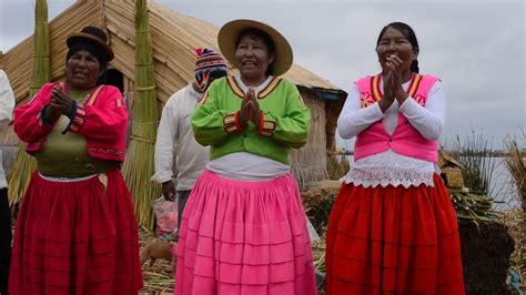 Uros Indians on the Titicaca Lake island greeting tourists with aymara ...