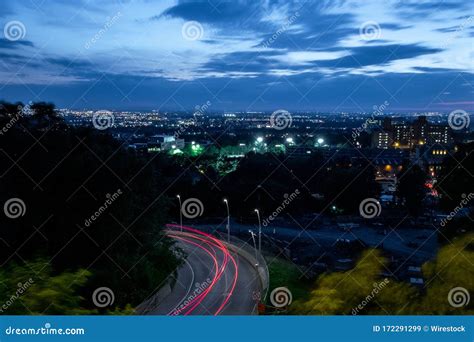 Night Photo of Trail Lights on a Curved City Road with a Cityscape at ...