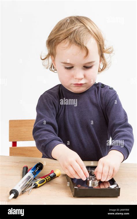 little girl repairing computer parts. studio shot with neutral grey background Stock Photo - Alamy
