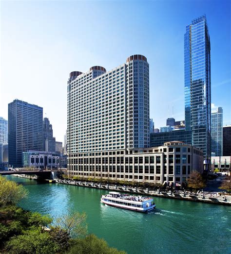 a boat traveling down a river in front of tall buildings and ...