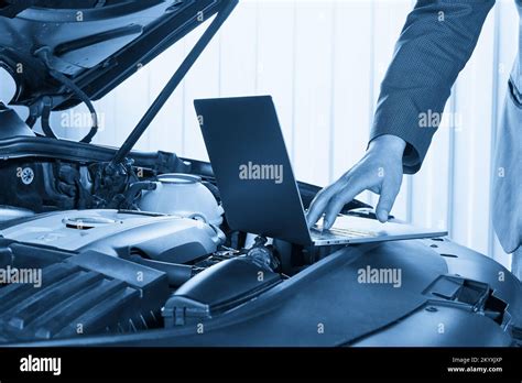 Car mechanic using computer in auto repair shop Stock Photo - Alamy