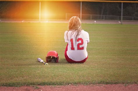 Free photo: Female Baseball Player Sitting on Grass Field Beside Helmet and Baseball Bat ...