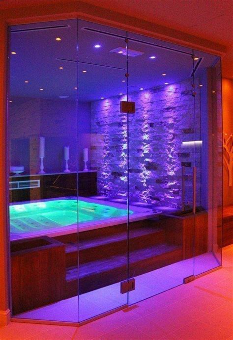an indoor swimming pool with purple lighting and stone walls in the background, surrounded by ...
