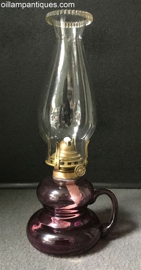 We are unsure of the age of this amethyst glass finger oil lamp. It appears to be hand blown and ...