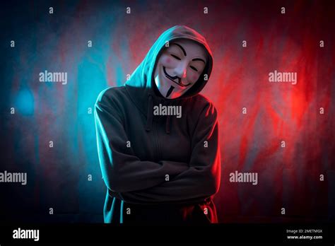 Hacker with anonymous mask with arms crossed, red and blue background ...