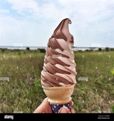 Vanilla chocolate soft serve ice cream cone by the shore Stock Photo ...