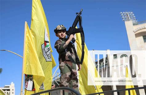 Palestinians holds up the yellow Fatah flag and the green Hamas flag ...