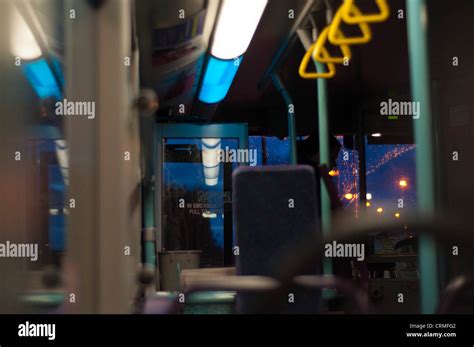 Inside an empty bus at night, showing some window reflections as well as some outside ...