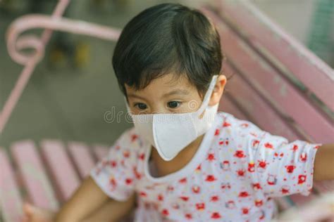 Child Wearing a Protective Face Mask on a City Street with Air ...