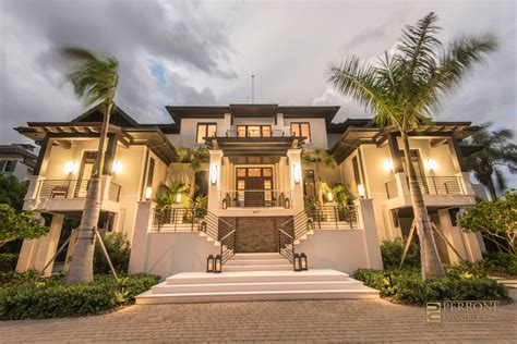 a large white house with palm trees on the front and stairs leading up to it