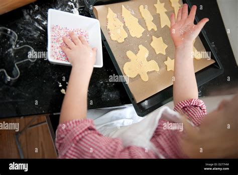 A little girl is decorating cookies for Christmas Stock Photo - Alamy