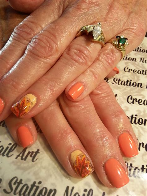 an older woman's hands with orange nail polish