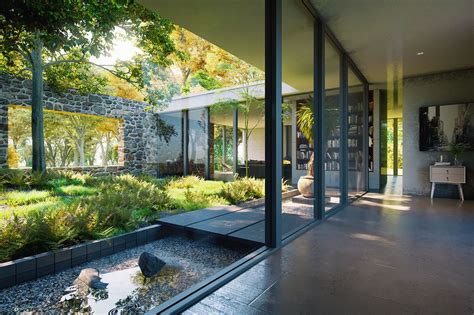 the interior of a modern house with glass walls and trees in the back ...