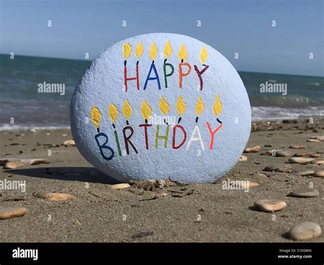 Joyeux anniversaire message multicolore sculptés sur une pierre avec fond de plage Photo Stock ...