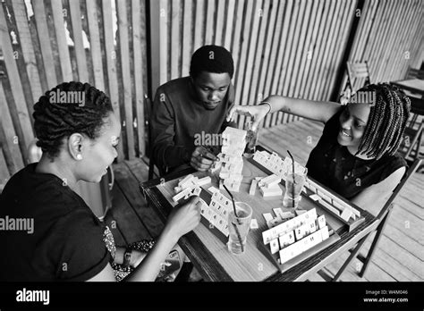 Group of three african american friends play table games Stock Photo - Alamy