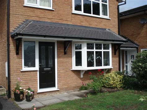 A tiled front door-and-window canopy supported by two pieces of solid ...