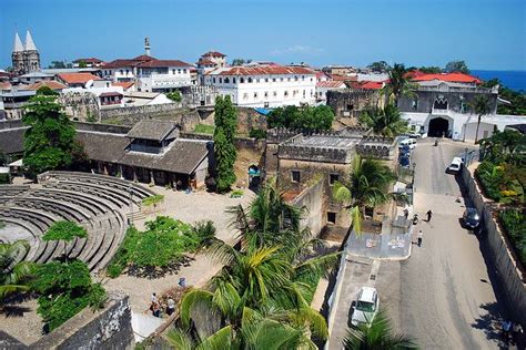 an aerial view of a city with lots of buildings and trees in the foreground