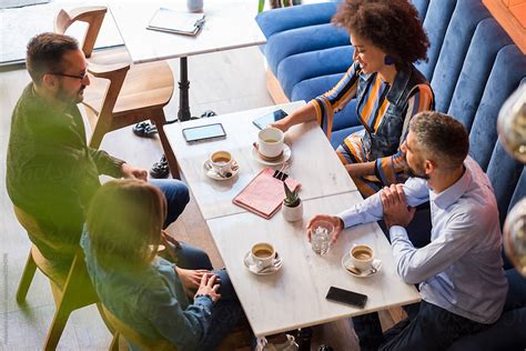 "Group Of People In The Modern Cafe Sitting Together And Drinking Coffee" by Stocksy Contributor ...