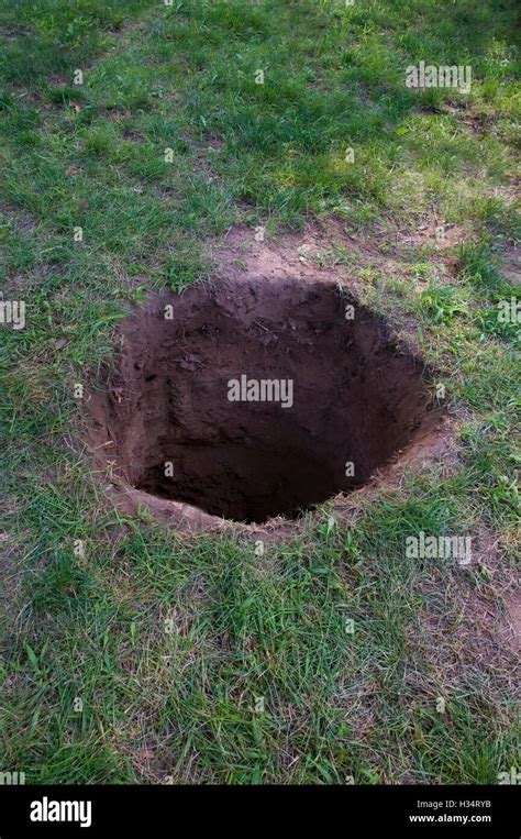 Deep dirt hole in ground or lawn Stock Photo - Alamy