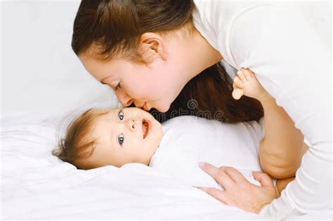 Mother Kissing Cute Baby On The Bed Stock Photo - Image: 49653934