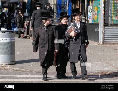 3 orthodox Jewish boys, likely teenagers, dressed very similarly walk ...