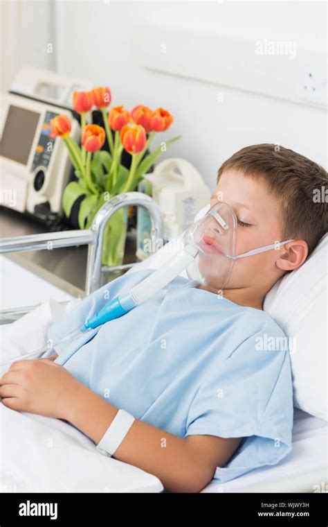 Sick little boy wearing oxygen mask in hospital bed Stock Photo - Alamy