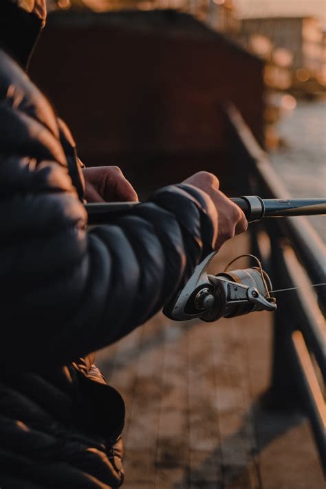 A Man in a Puffer Jacket Holding a Fishing Rod · Free Stock Photo