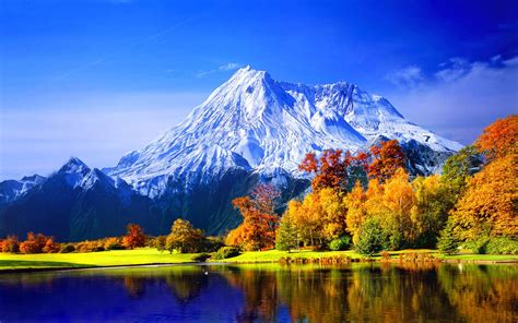 the mountain is reflected in the still water of the lake and trees are changing colors