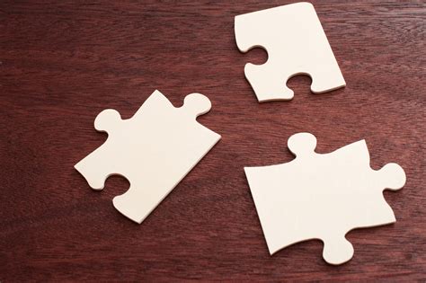 Free Stock Photo 12737 Three blank puzzle pieces over brown table | freeimageslive