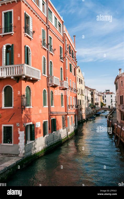 Canal lined with historical Venetian architecture with a bridge in the background Stock Photo ...