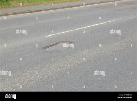 Pot holes in Carterton, Oxfordshire UK. 13th May 2018. UK Weather: Pot holes in West Oxfordshire ...