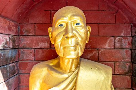 Golden Statue Against a Brick Background at a Buddhist Temple in ...