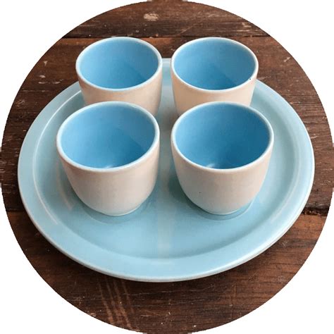 four blue cups and saucers on a plate