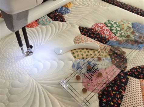 a close up of a quilting machine on a table with several pieces of fabric