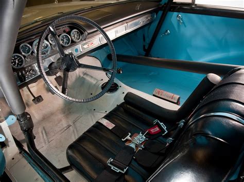 the interior of an old car with black leather seats and steering wheel, including a blue dash board