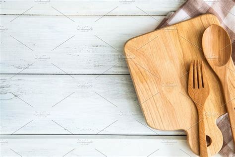 wooden utensils and spoons on a checkered tablecloth, top view