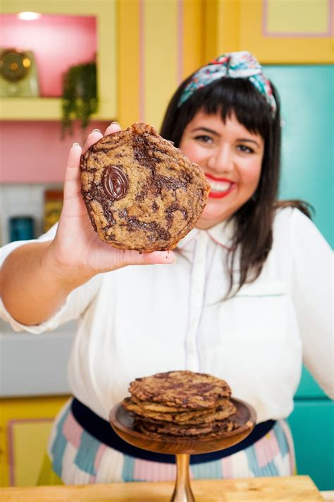 a woman holding up a chocolate chip cookie