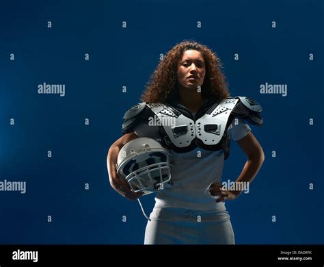 Portrait of female american football player with shoulder pads and ...