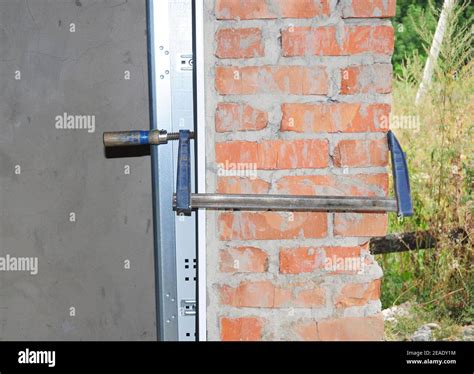 Garage door installation, assembling the door frame to the door lintel with a working tool Stock ...